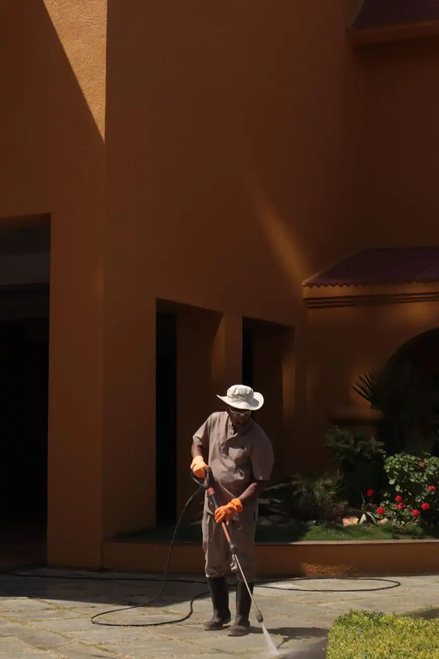 Technician pressure washing a stone courtyard